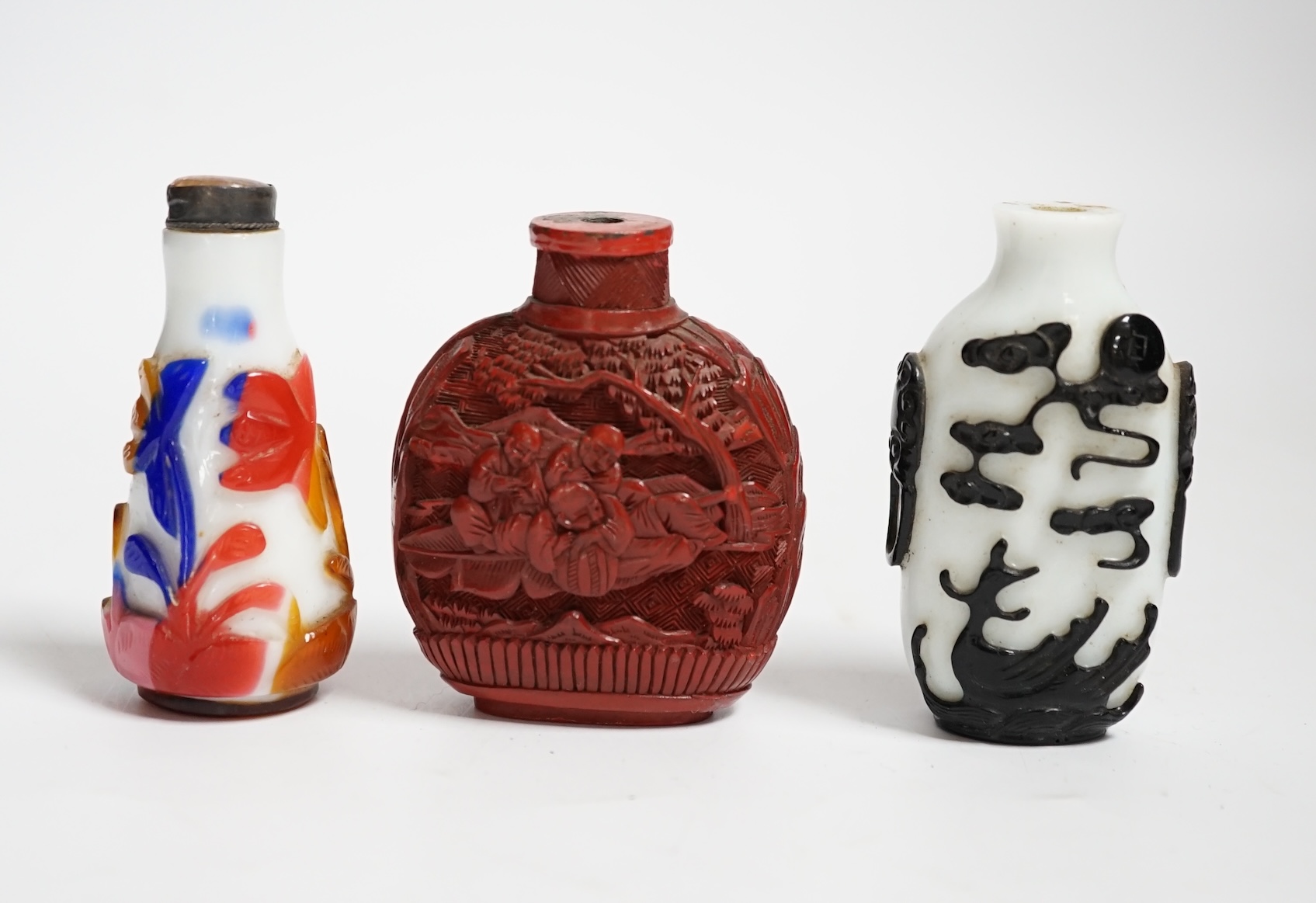 Three Chinese snuff bottles including a 19th century cinnabar lacquer ‘boys’ snuff bottle, largest 7cm high